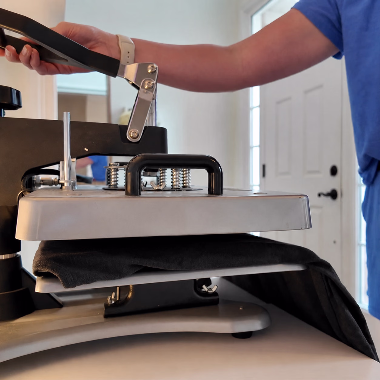 Pre-pressing a blank t-shirt on a heat press to remove moisture before applying a DTF transfer